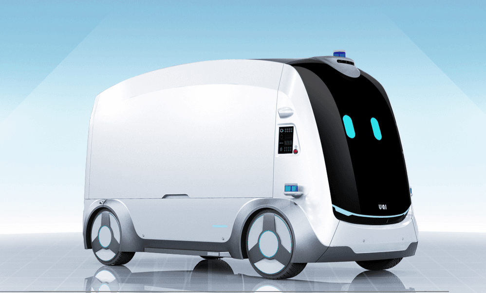 Futuristic white autonomous delivery vehicle with a black digital face and glowing blue eyes.